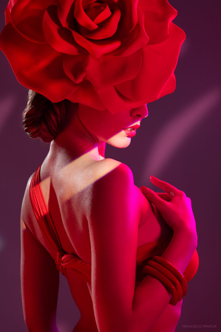fotografia beauty con una modella vestita di rosso con un cappello rosso a forma di rosa e luci spettacolari realizzata da FRANCESCO FRANCIA fotografo di moda